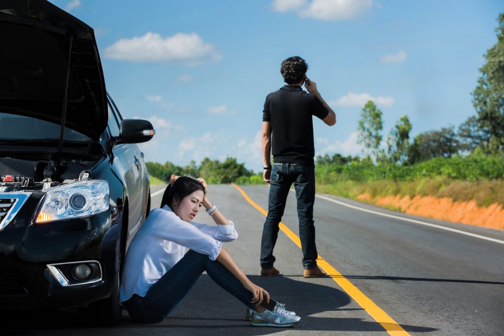 Man On Call Phone With Wife By Tire Needing Roadside Assistance