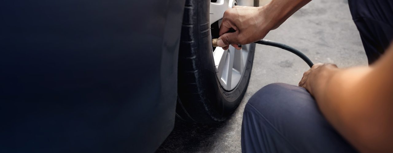 Tow Driver Using Air Compressor For Flat Tire Service