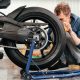 Young man cleaning and preparing motorcycle for transport.