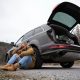 man with a broken car on the side of the road